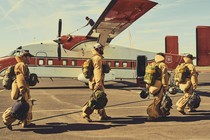 Smoke jumpers in gear boarding a plane