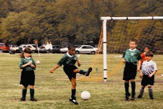Photograph of a young Clint Smith playing soccer
