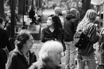 Black-and-white photo of masked woman on a crowded street