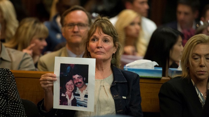 Woman holds photo of young couple