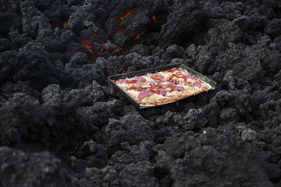 Cheese melts as a pizza is cooked on hot volcanic rocks.