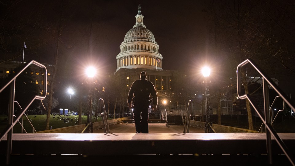 A police officer walks through the grounds of the U.S. Capitol on the night of January 6, hours after the insurrection.