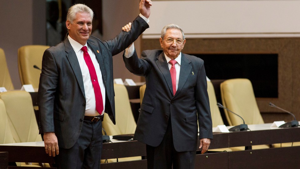 Newly elected Cuban President Miguel Diaz-Canel reacts as Raul Castro raises his hand during the National Assembly in Havana on April 19, 2018.