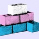 White, blue, and pink cement bricks stacked in a pyramid