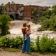 Photograph of a mother holding her daughter in front of an overflowing river in Vermont