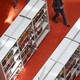 People walk between library shelves