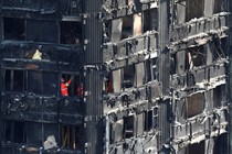 Members of the emergency services work inside burnt out remains of the Grenfell apartment tower on June 18, 2017.