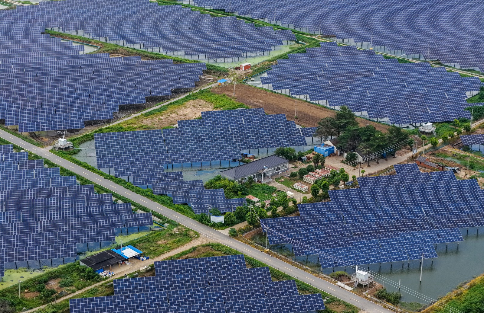 Many solar panels stand above several ponds in China, seen from above.