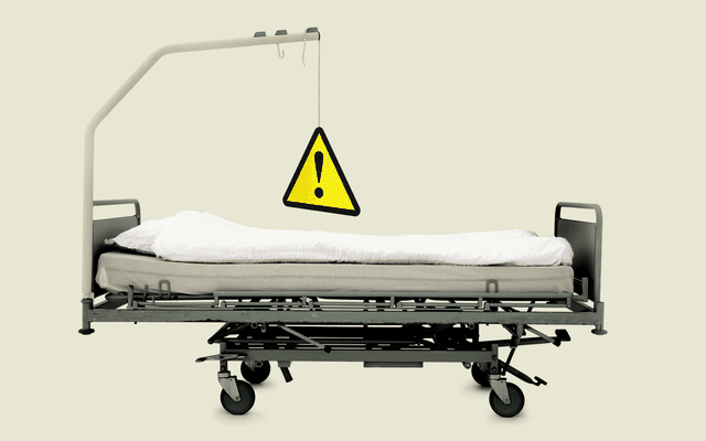 A yellow warning sign hangs above a gurney.