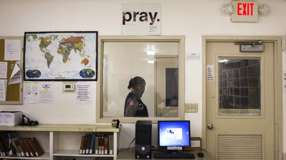 A security official walks past a prison library. 