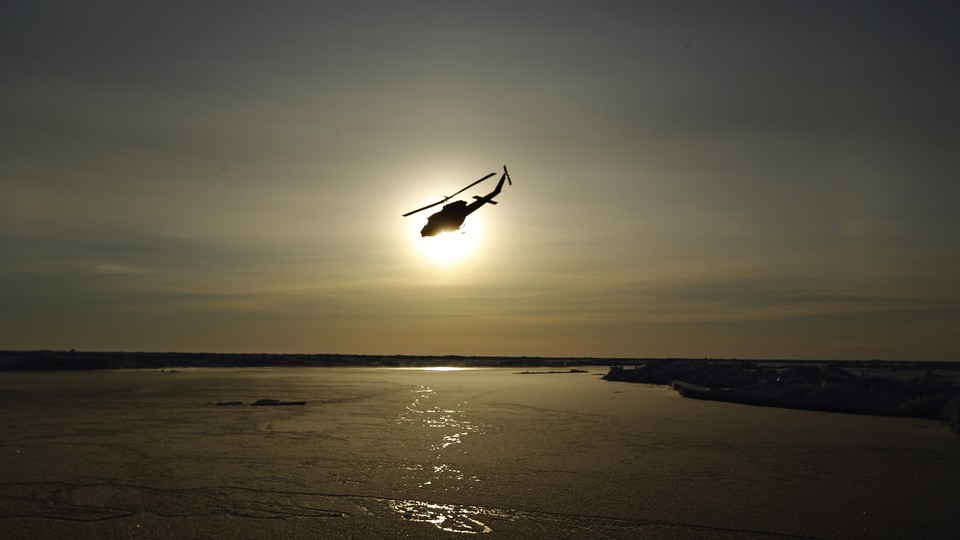 A helicopter flies over Arctic ice toward the Applied Physics Laboratory Ice Station.