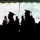 Female college graduates stand in a line. 