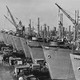 black and white picture of large cargo ships lined up in a shipyard.
