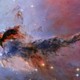 Glowing and dark sections of a huge cloudlike structure in space, backdropped by stars