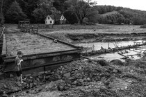 A boy plays near the remainder of a washed-out road near his family's home in Watauga County on September 27, 2024.