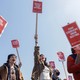 Labor-union organizers holding signs that read, "Rebuild a Fighting Labor Movement!," "Demand Starbucks Stop Cutting Employee Hours!" and "Fight Starbucks' Union Busting!"