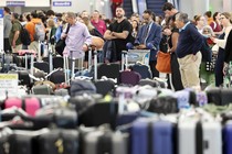 Travelers wait for their bags at Los Angeles International Airport on June 29.