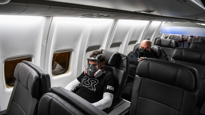 A man wears a gasmask as he travels in a flight from Miami to Atlanta in Miami, on April 23, 2020