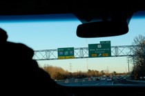 Highway signs for I-95 and I-295 at the exit for New Brunswick in New Jersey, viewed through a car windshield