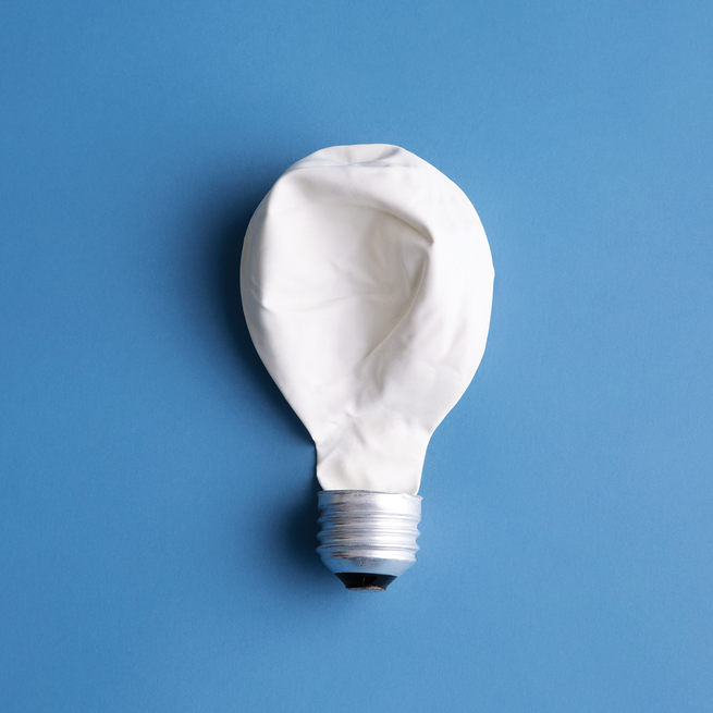 light bulb with deflated white balloon instead of glass on blue background