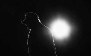 Donald Trump in silhouette, backlit by a single circle of light