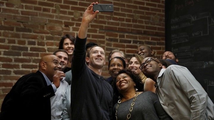 Mark Zuckerberg taking a selfie with a group of people