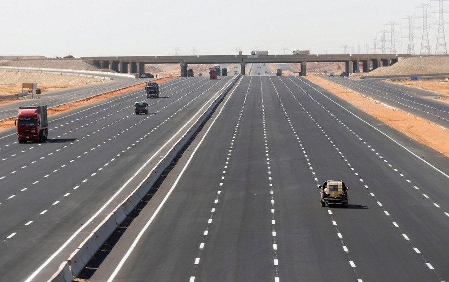 A very wide highway, with only a few vehicles using it