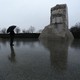 A person, carrying an umbrella, at the Martin Luther King Jr. Memorial in Washington, D.C.