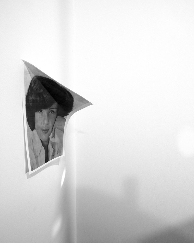 a woman's portrait peeling off a white wall
