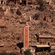A single damaged tower stands on a hillside, surrounded by the rubble of dozens of smaller buildings, destroyed by an earthquake.