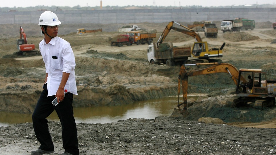 A Chinese engineer watches excavation work at the construction site for the Hambantota port.