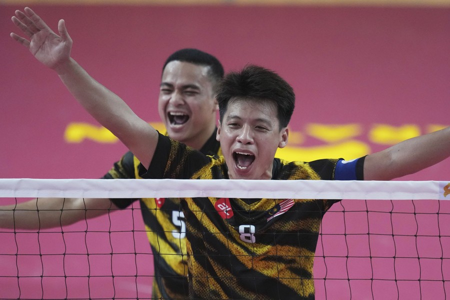 Two players celebrate on court after scoring.