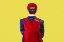 Young man in a suit wearing MAGA hat and red backpack