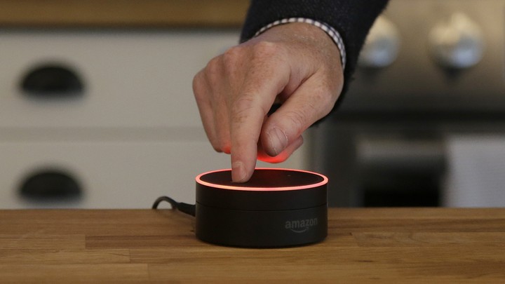 A man mutes an Amazon Echo Dot