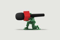 A toy soldier holds a microphone like a machine gun