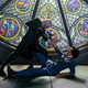 Two characters from 'Cowboy Bebop' in a standoff in front of a stained-glass window