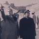 A mirrored sepia-toned photo of President Richard Nixon and Secretary of State William Rogers with Chinese Deputy Premier Li Xiannian during a visit to the Great Wall of China.
