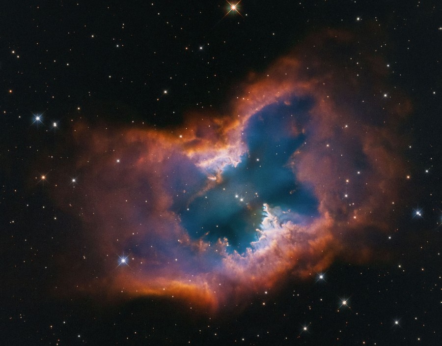 Clouds of gas and dust form a bright nebula in the night sky, vaguely shaped like a moth.