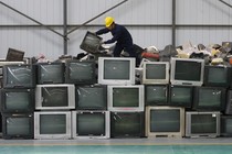 An employee arranges discarded televisions at an electronic waste recycling factory in Wuhan, China, in 2011.