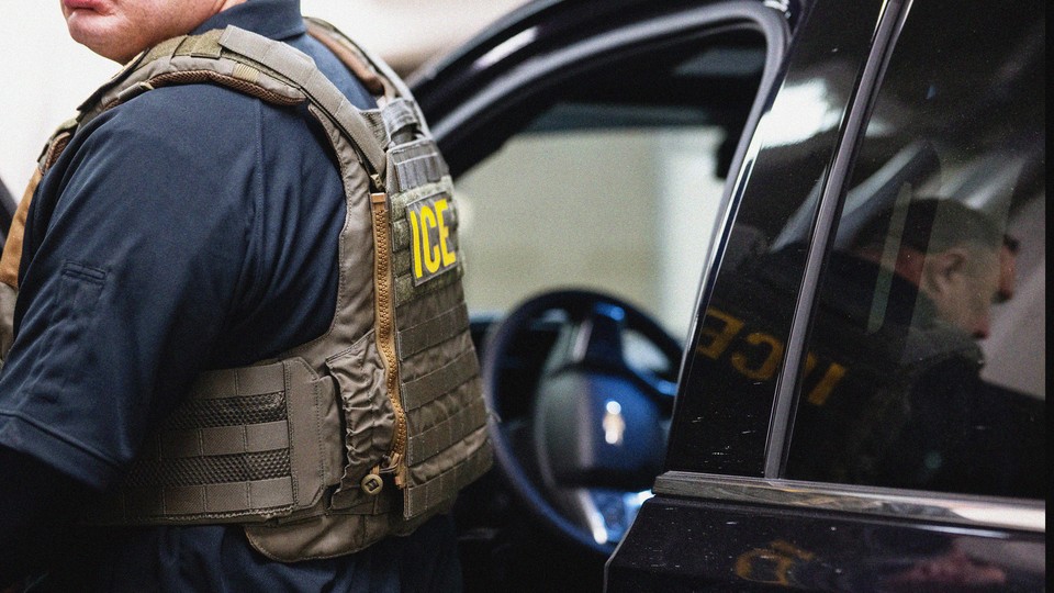 Photograph of a man in an ICE tactical vast seen getting out of a black car