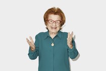 A photo of Dr. Ruth holding out her hands and smiling