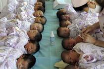 Two rows of babies waiting to receive vaccines 