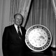 A photograph of Gerald Ford in front of a lectern bearing the seal of the vice president.