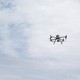 A soldier and two flying military drones.