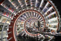 The interior of a bookstore, looking down a tunnel made of spiraling bookshelves