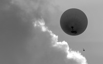 A black-and-white photo of a high-altitude weather balloon, as seen from below