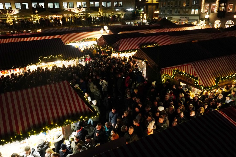 People crowd around market stalls.