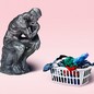 Auguste Rodin's sculpture 'The Thinker' next to a basket of laundry