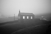 A photo of a building in the middle of a foggy field