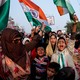 People hold signs and India's national flag during a protest in New Delhi, India.